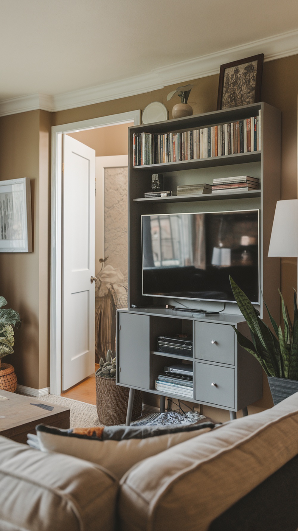 A compact entertainment center with a TV, books, and decor in a small apartment living room.